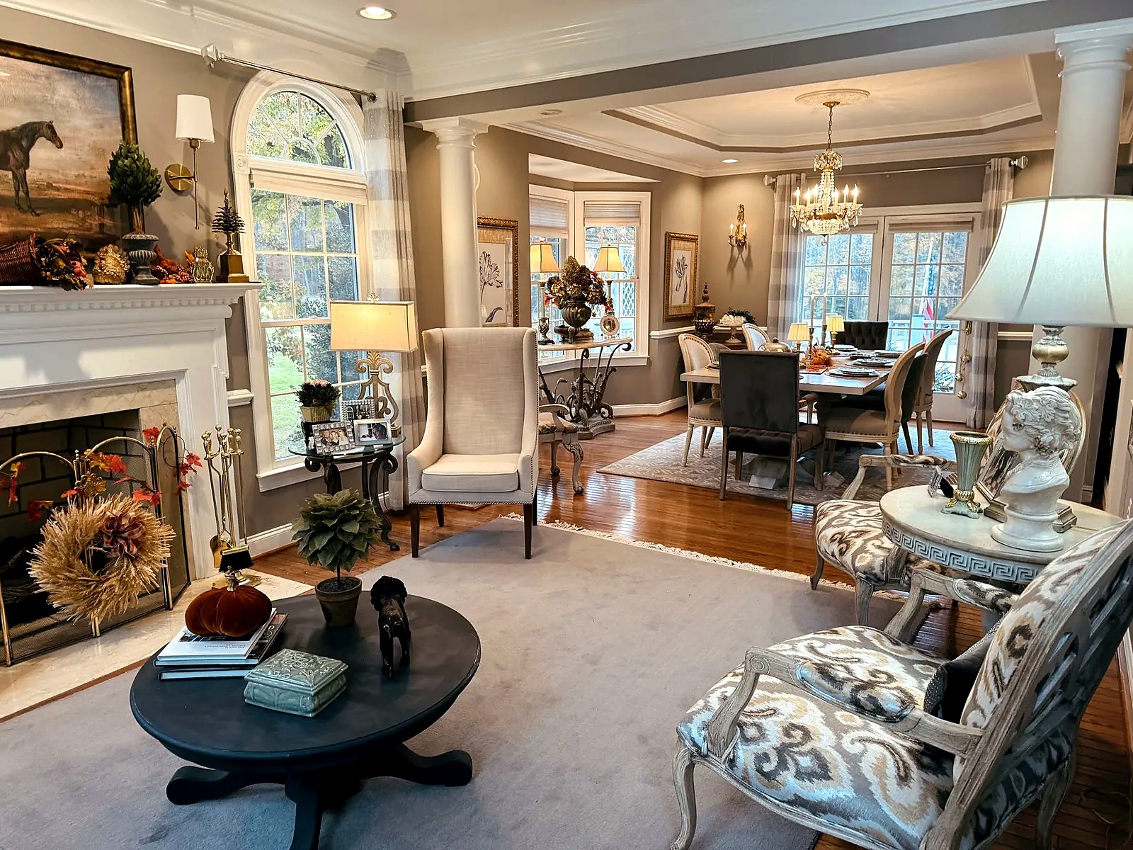 Living and dining room with a fireplace and wingback chair